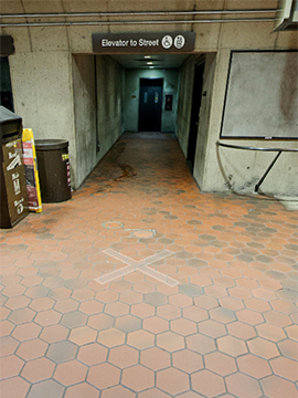 A picture of the path to the elevator that goes to street level. The picture shows the elevator is set into the rest of the station wall.